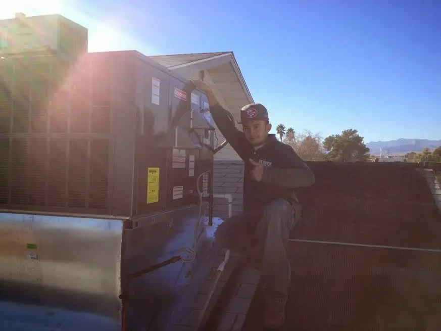 HVAC technician performing Air Duct Repair on a rooftop unit in Central City